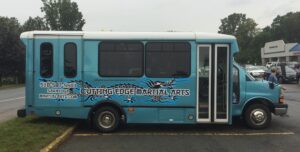 Blue martial arts shuttle bus with graphics