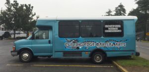 Blue shuttle bus with martial arts graphics