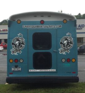 Rear of teal martial arts shuttle bus